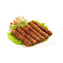 Load image into Gallery viewer, Plated dish of seekh kebabs with salad on a white background