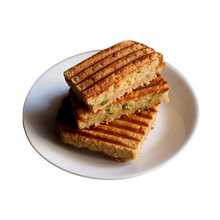 Load image into Gallery viewer, Three grilled sandwiches stacked on a white plate with a white background

