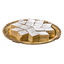 Load image into Gallery viewer, Square pieces of a dessert on a decorative gold platter against a white background - kaju katli

